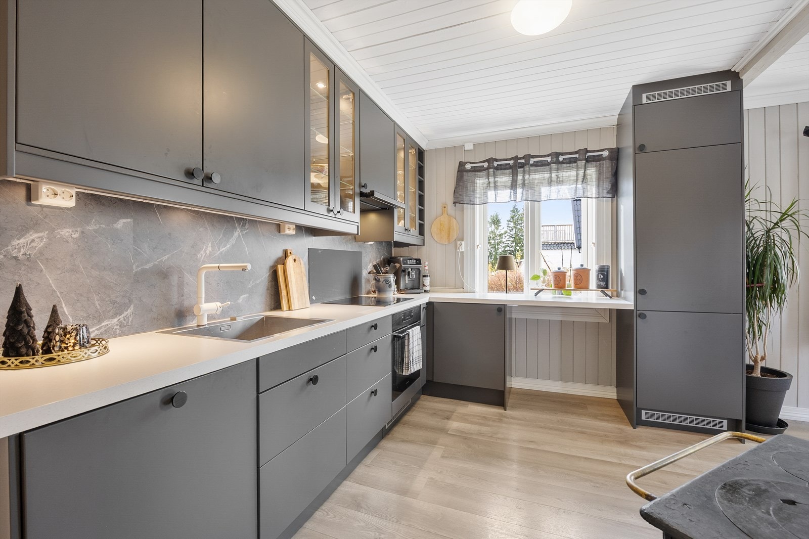 Kjøkkeninnredningen er vinkelformet og arbeidsvennlig. Galleribilde