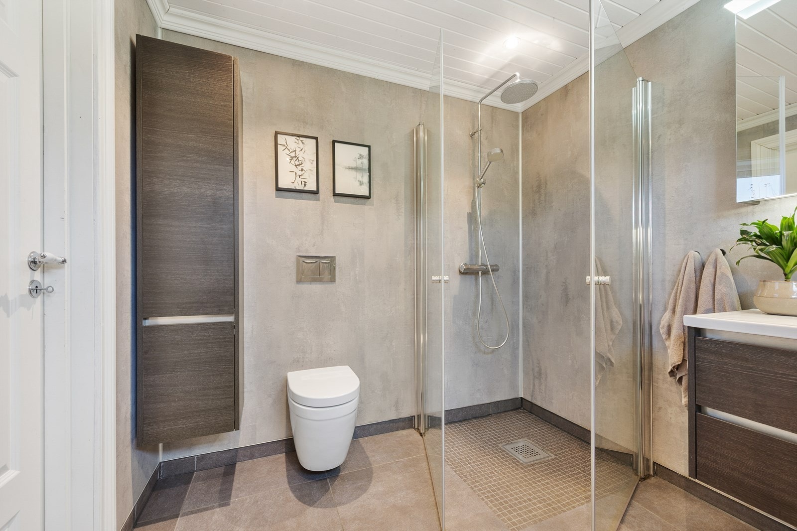Videre har badet vegghengt toalett og dusjhjørne med innfellbare glassdører og regnfallsdusj, samt lun varme i gulvet. Galleribilde