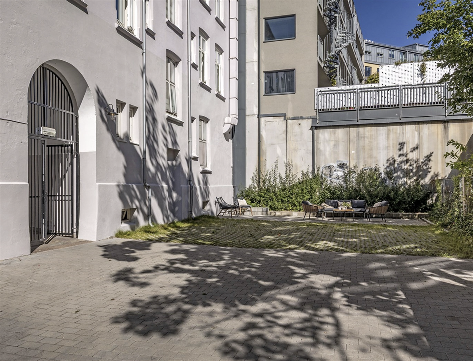 Bakgård med sittegrupper og mulighet for parkering. Galleribilde