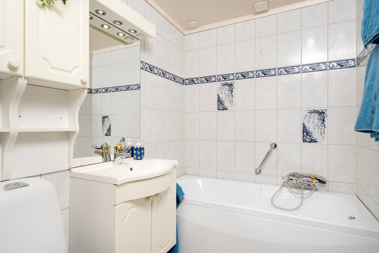 Flislagt baderom innredet med servant, wc og badekar Galleribilde