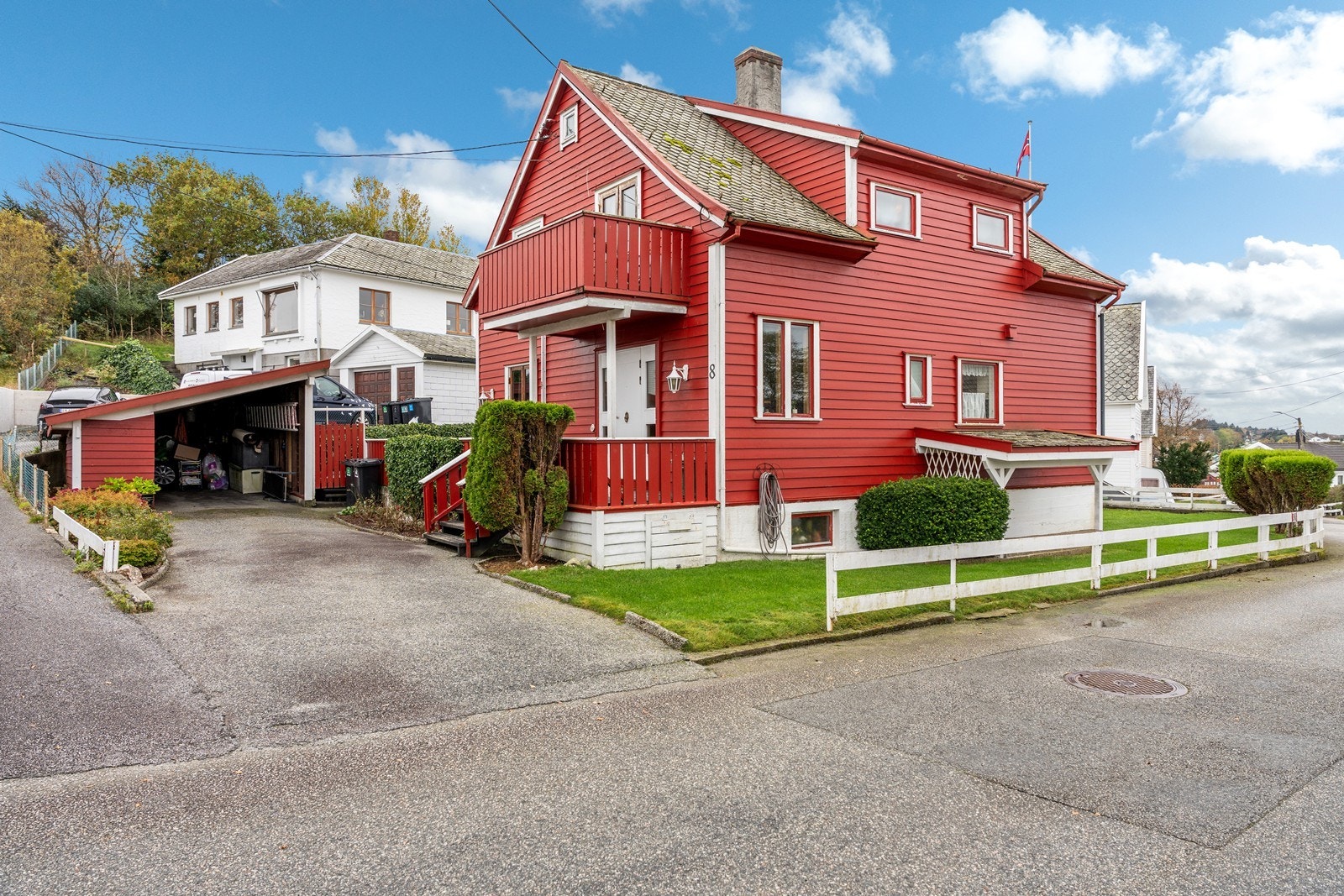 Asfaltert gårdsrom med carport Galleribilde