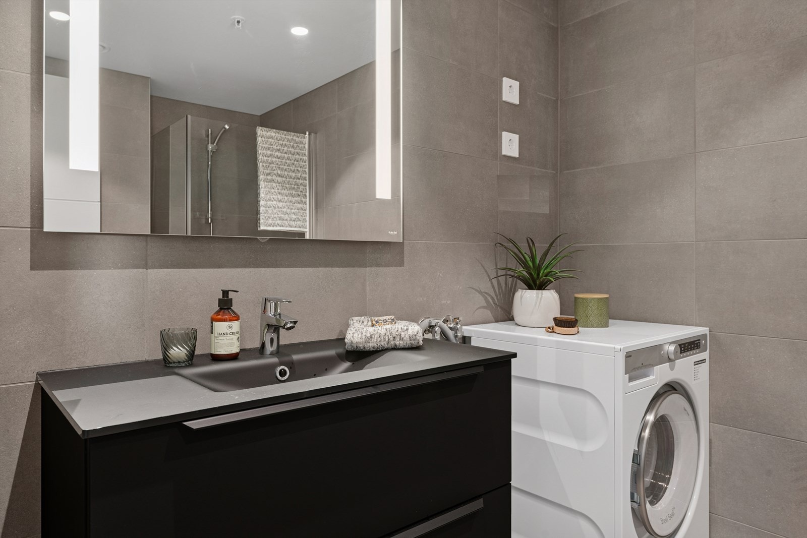 Rommet er utstyrt med 90x90 dusjnisje, 80 cm baderomsinnredning med speil, Tece innebygget sisterne og opplegg for vaskemaskin. Galleribilde