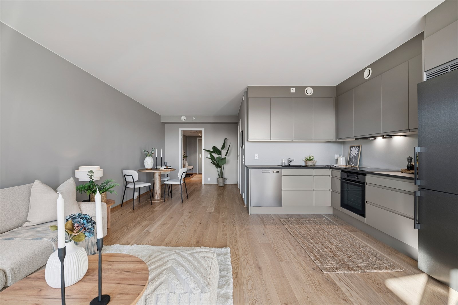 Den åpne løsningen mellom stue og kjøkken gir rom for både en komfortabel sofagruppe og en innbydende spiseplass. Galleribilde