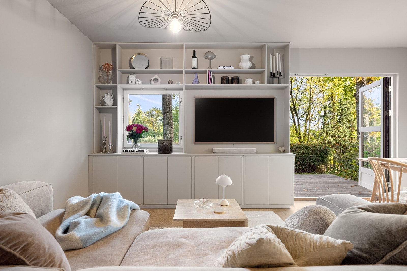 I oppholdsrommet er det laget en plassbygget bokhylle med medieløsning og praktiske skap for lagring Galleribilde