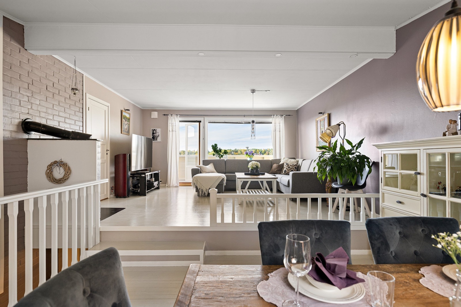 Gulv i to høyder deler stuen inn i soner som enkelt lar seg utnytte med sittegrupper for mange. Galleribilde