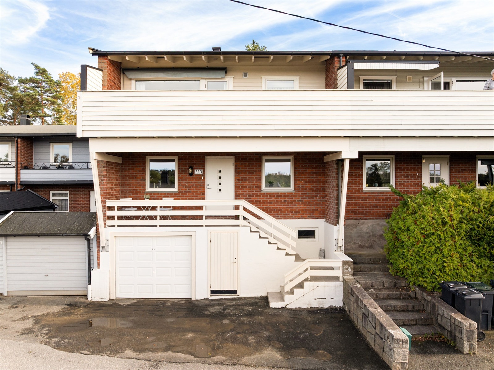 Fliser ble i 2022 lagt både i trapper, på repos og altan foran underetasjen. Biloppstillingsplass er det både i integrert garasje og foran denne. Galleribilde