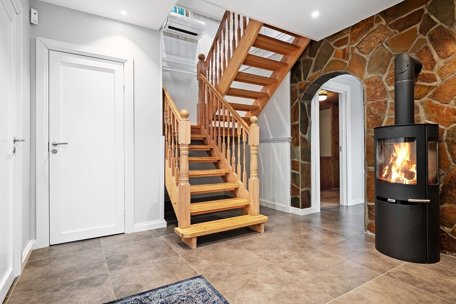 Flott gang med peisovn som bidrar til varme og hygge på kjøligere vinterdager. Galleribilde