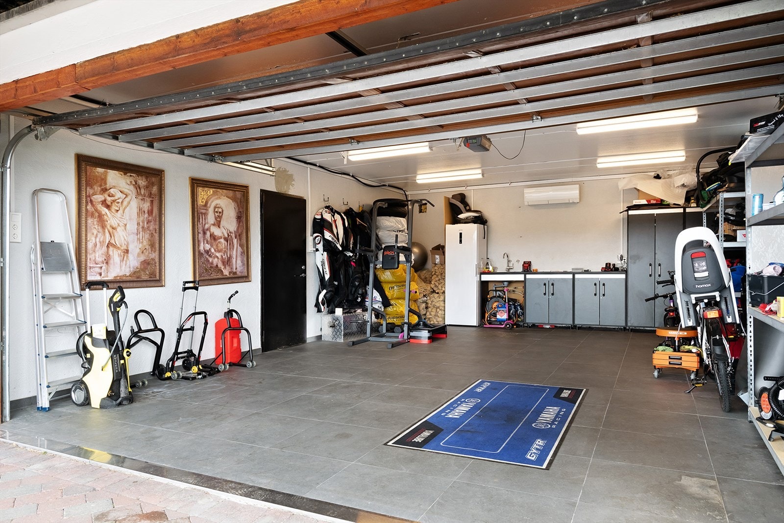 Romslig garasje med gode oppbevaringsmuligheter og arbeidsområder. Galleribilde