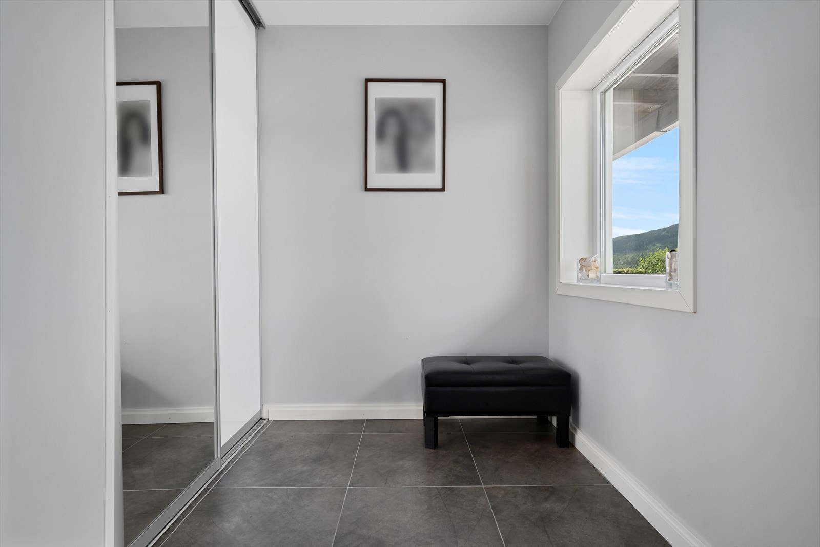 Flislagt inngangsparti med skyvedørsgarderobe. Galleribilde