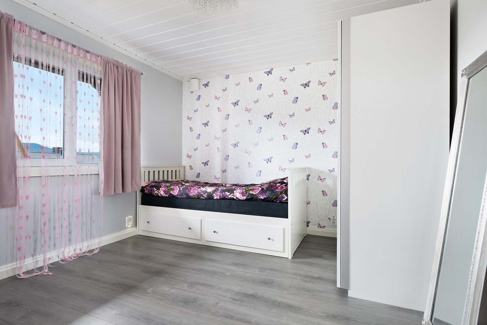 Lyst barnerom med god plass til seng og garderobeløsning. Galleribilde