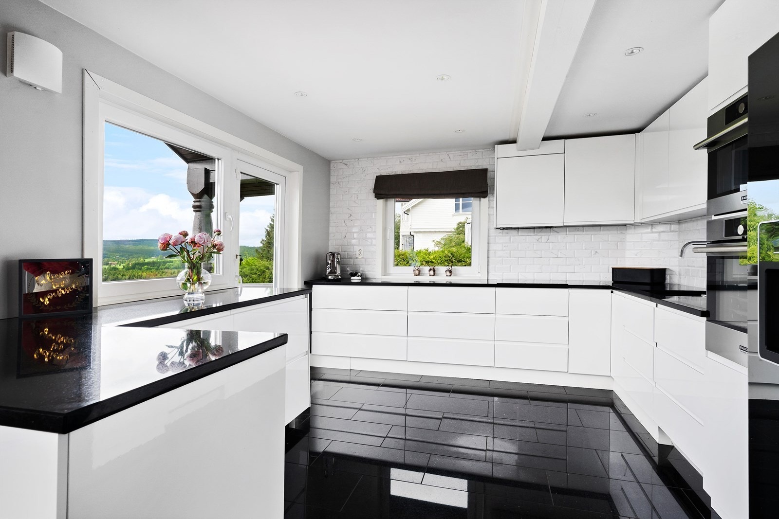 Kjøkkenet har flotte fliser mellom benkeplate og veggskap samt utgang til terrassen. Galleribilde