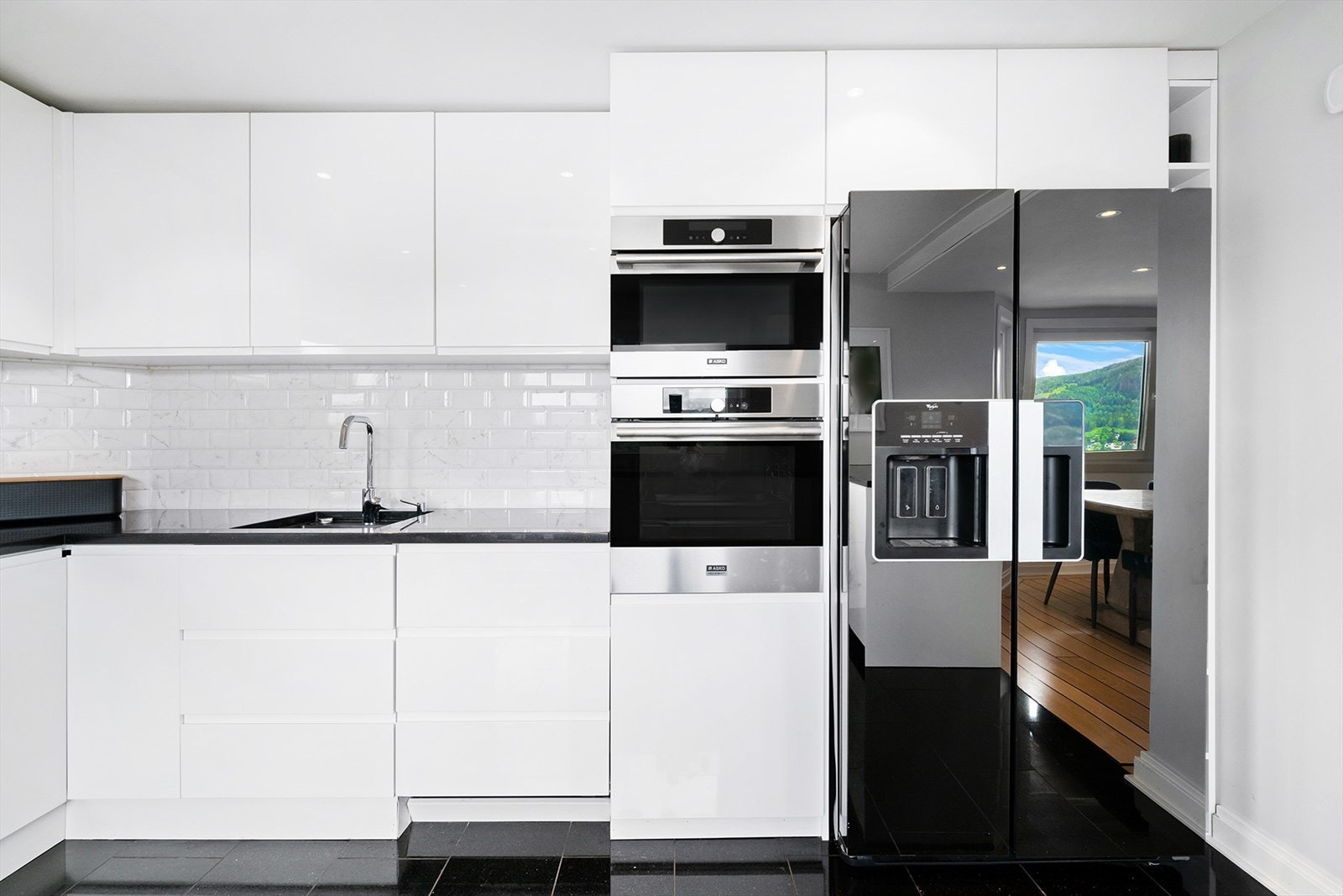 Integrert oppvaskmaskin, mikrobølgeovn, stekeovn og nedsenket induksjonstopp i kjøkkeninnredningen. Galleribilde