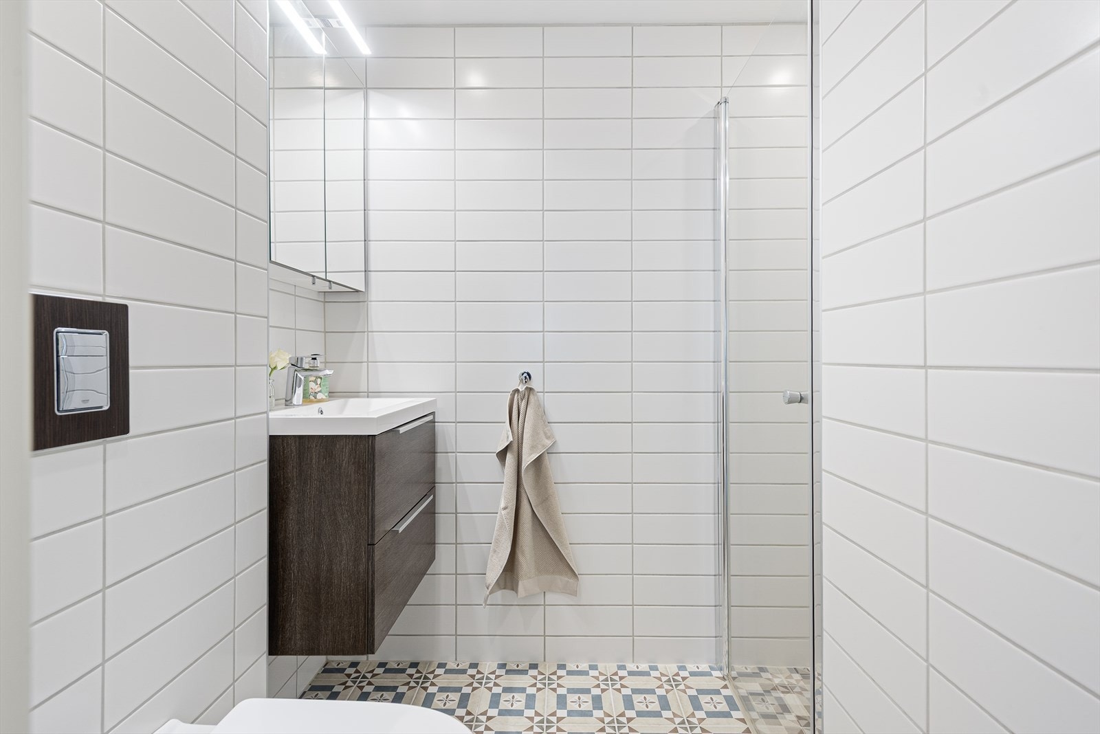 Baderom i 1.etasje med vegghengt toalett, servantskap og dusjhjørne/vegger Galleribilde