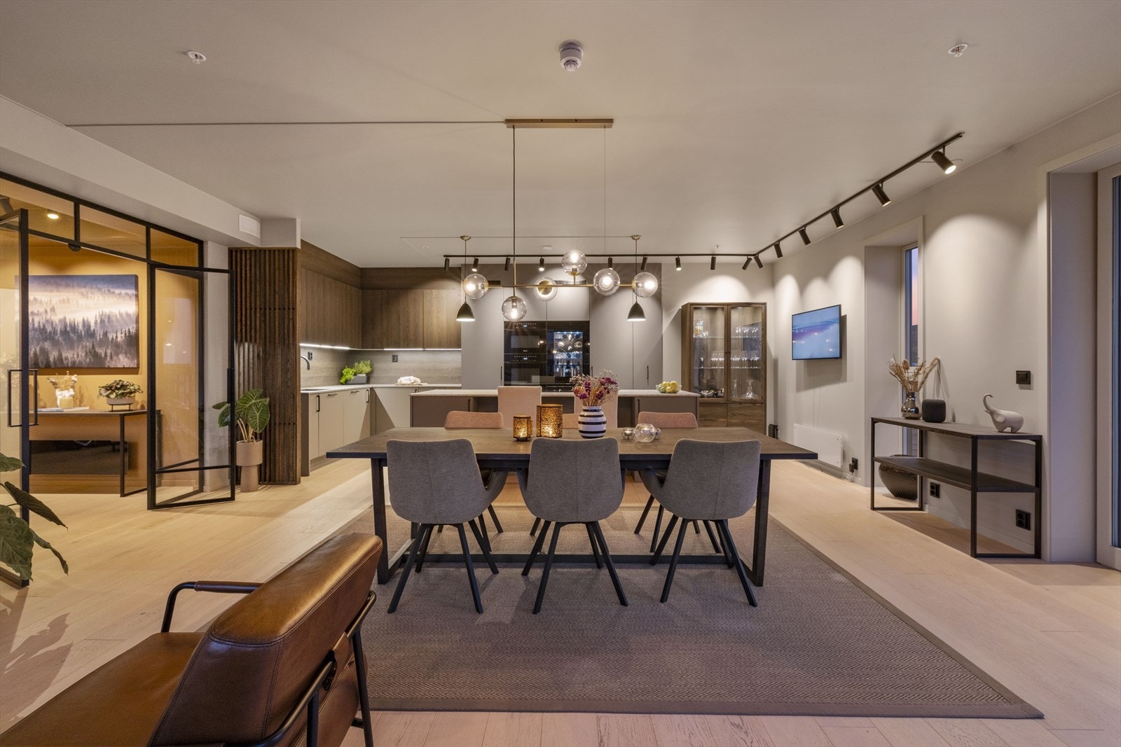 Den lekre kjøkkenøya blir et naturlig samlingspunkt, og stuene kan enkelt deles av med stilrene glassdører i sort smijern. Galleribilde