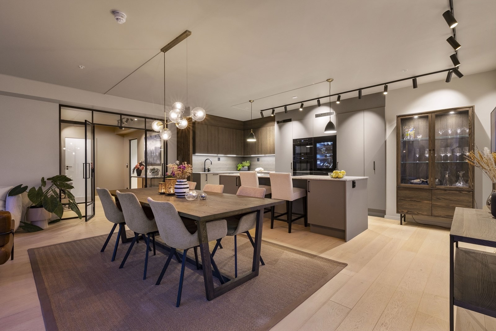 Åpen stue- og kjøkkenløsning med en elegant kjøkkenøy som blir hjemmets naturlige midtpunkt - perfekt for både hverdagsliv og stilfulle selskap. Galleribilde