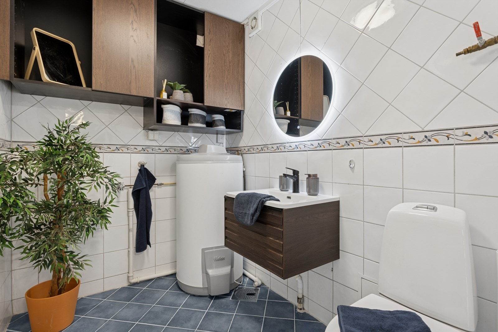 Praktisk vaskerom med opplegg for vaskemaskin, servant med speil, belysning og toalett. Galleribilde