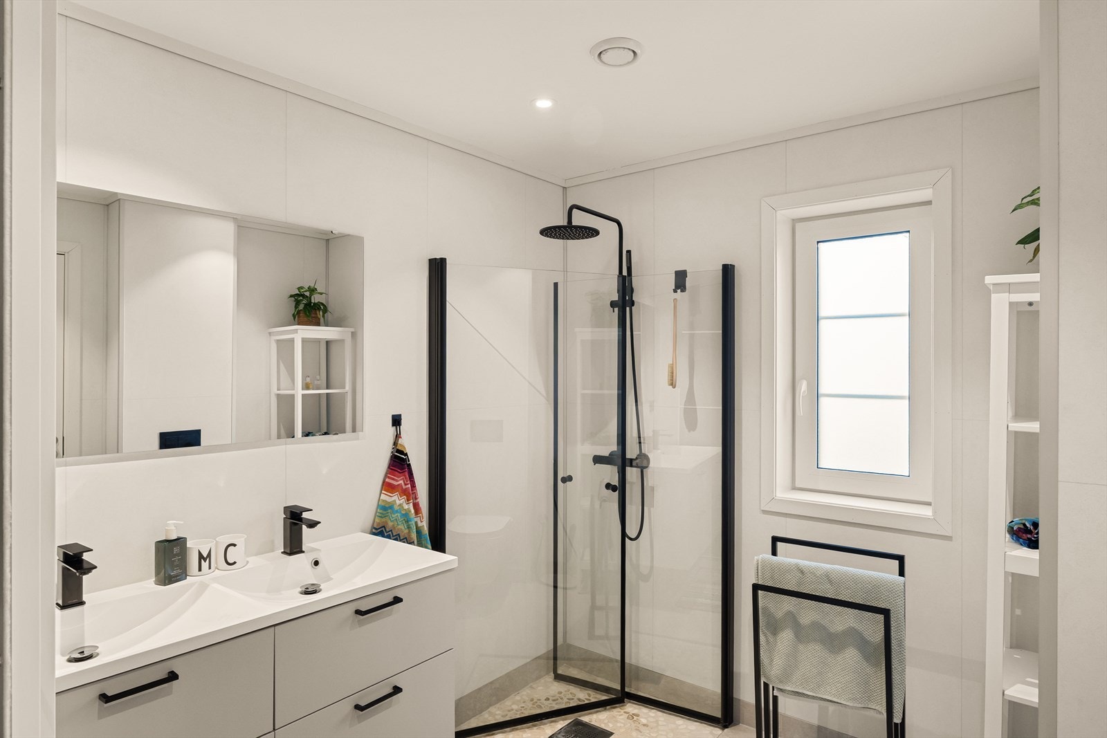 Moderne innredning med skuffer under servnat og dusjdører i klart glass Galleribilde