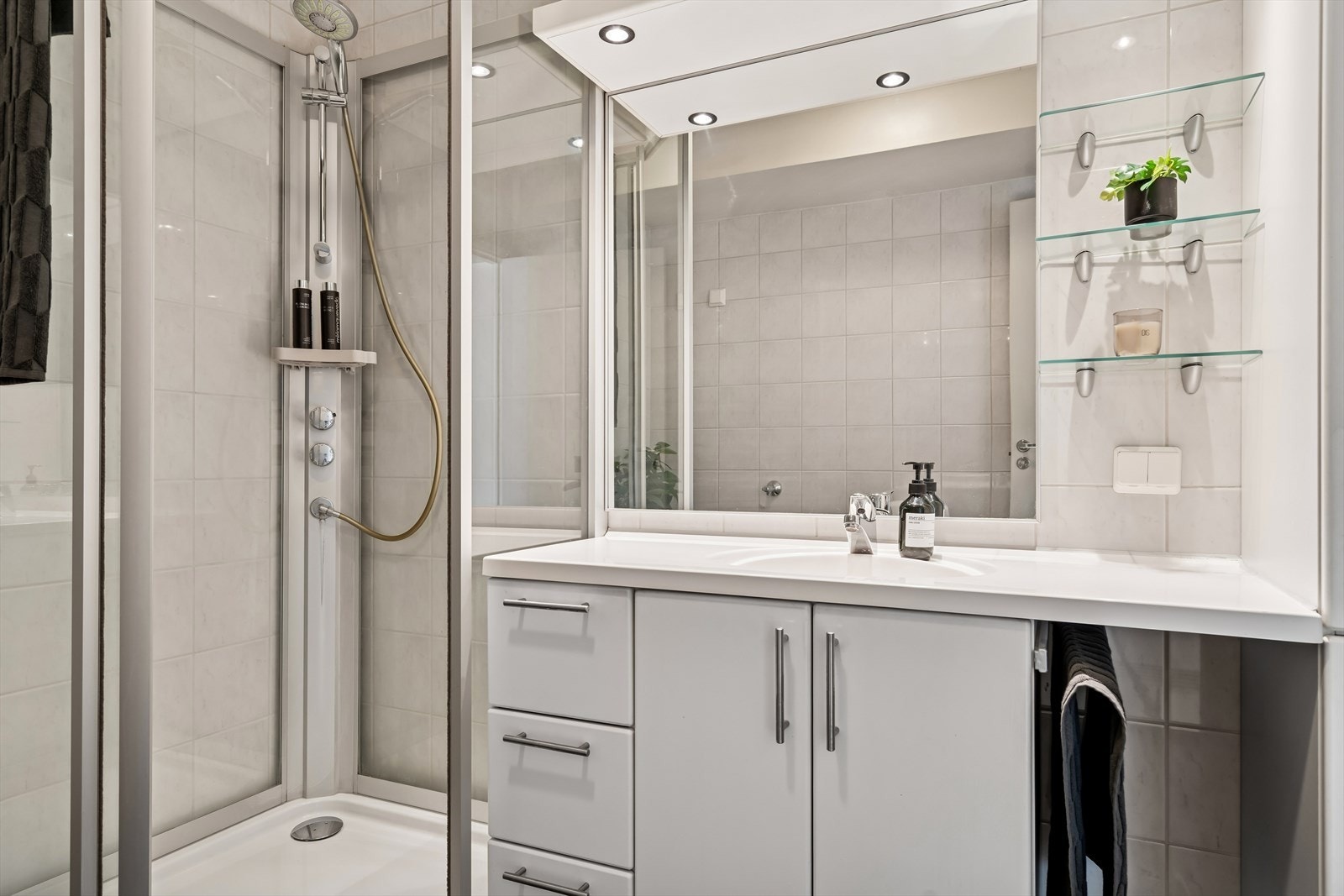 Badet er utstyrt med innredning med nedfelt servant, toalett, dusjkabinett og opplegg for vaskemaskin. Galleribilde