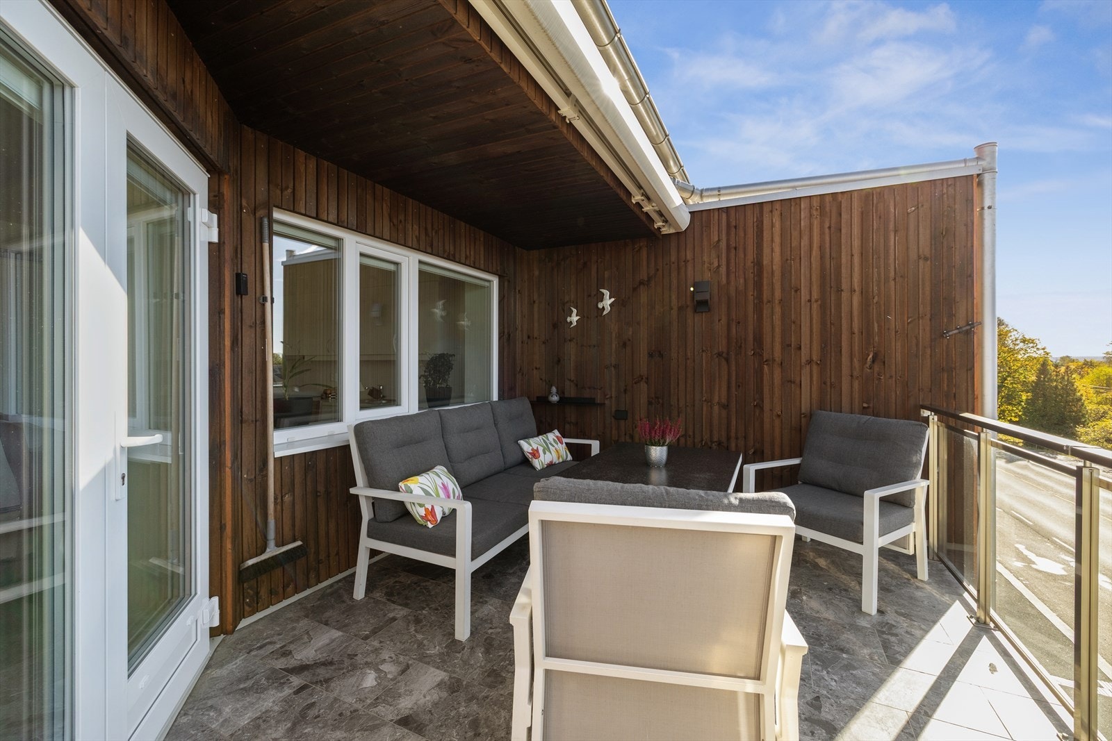 Solrik balkong med til å innrede med hagemøbler, grill og blomsterpotter. Galleribilde