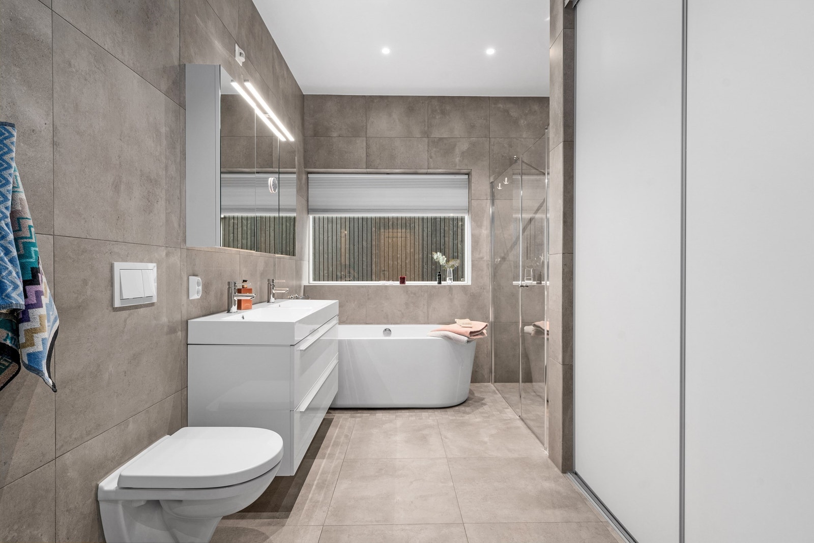 Praktisk løsning med opplegg for vaskemaskin og tørketrommel bak skyvedør. Galleribilde