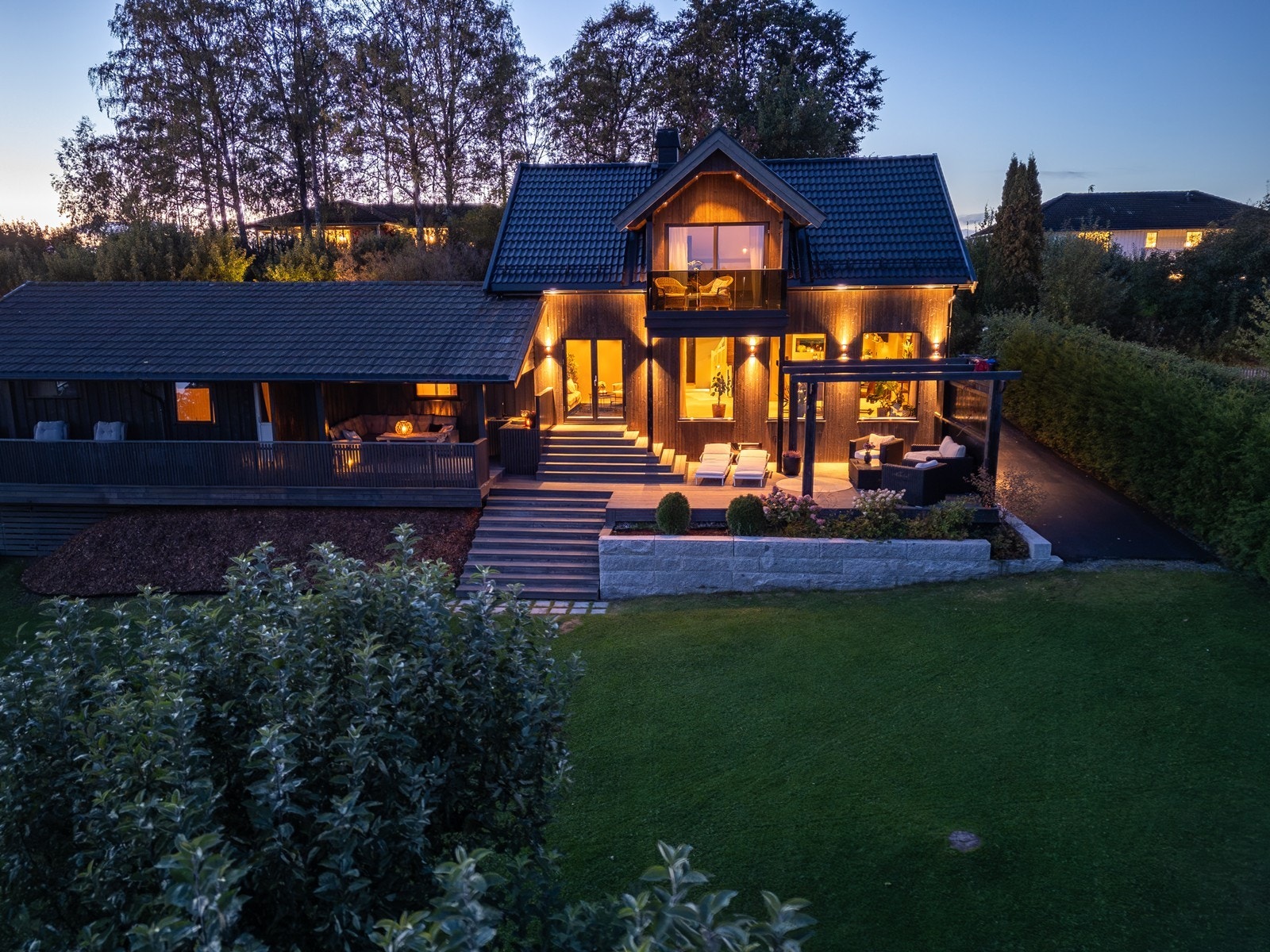 Boligen og eiendommen sett fra luften på kveldstid. Galleribilde