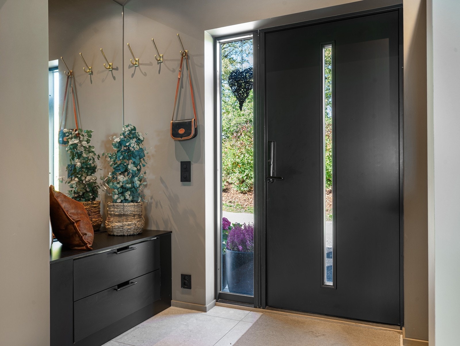 Velkommen inn i en lys og romslig entré med en massiv ytterdør med elektronisk kodelås. Galleribilde