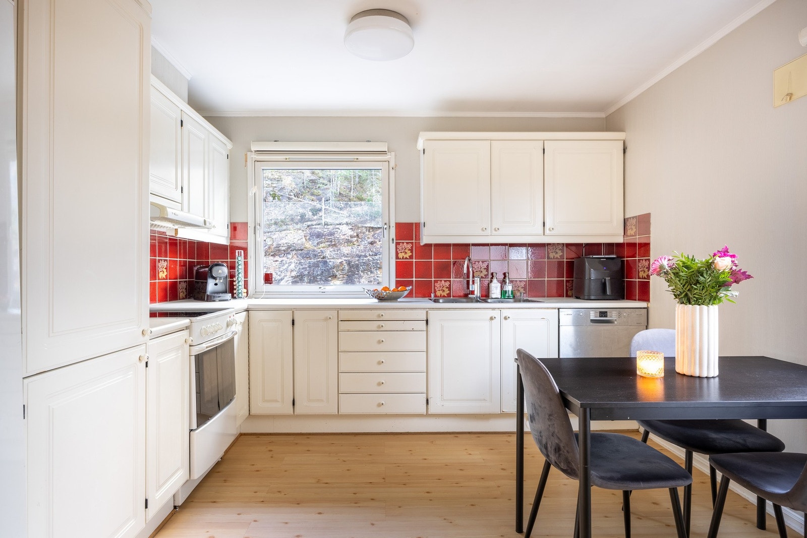 Romslig spisekjøkken med profilerte fronter og benkeplate av laminat med dobbel oppvaskkum av rustfritt stål. Galleribilde