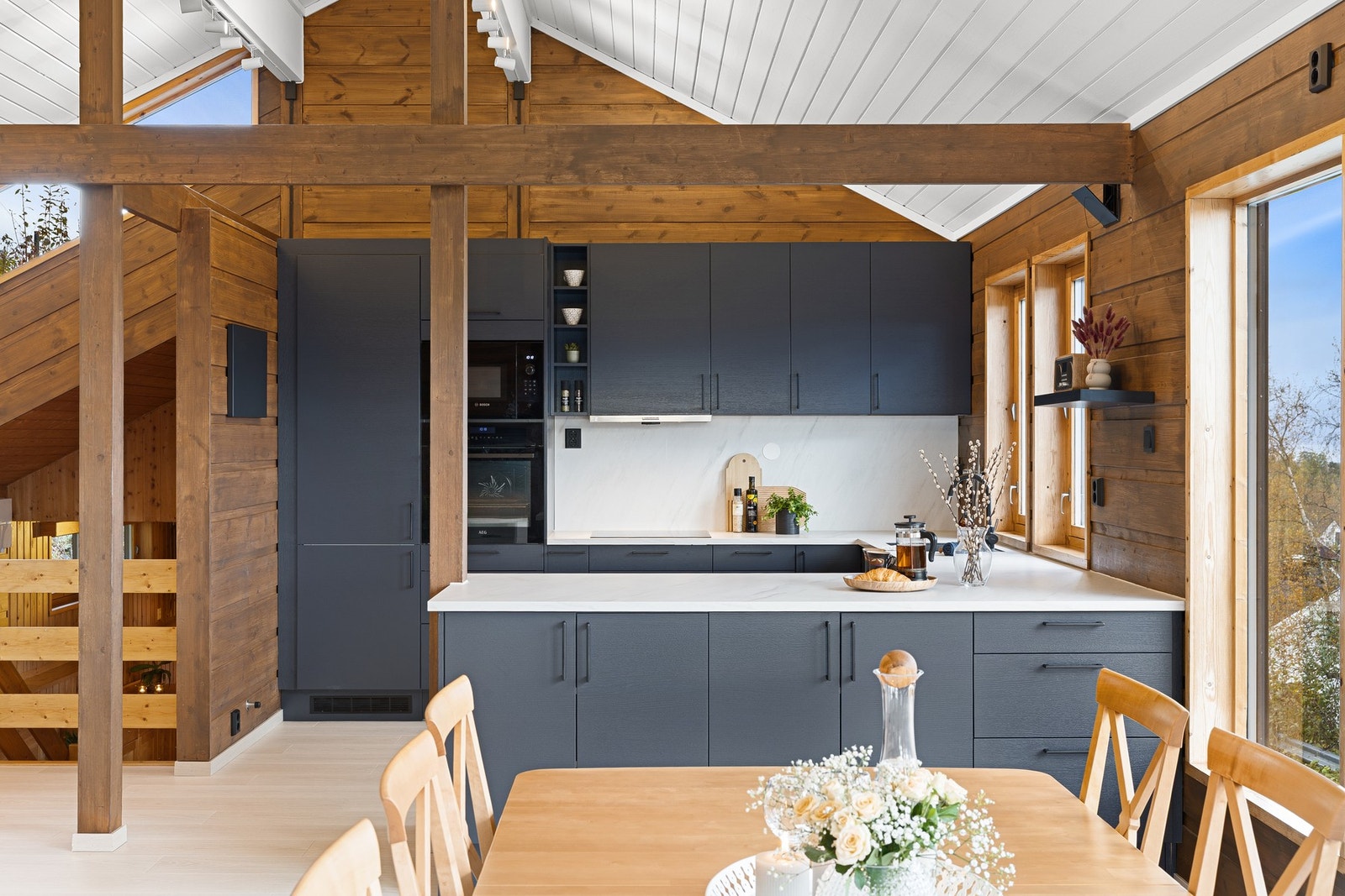 Kjøkkeninnredning i glatte fronter og benkeplate med nedfelt platetopp og underlimt vaskekum. Galleribilde