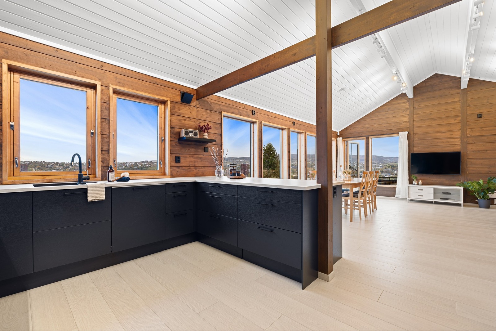 Åpen stue- og kjøkkenløsning på drøye 50 kvm. Rommet har arkitektonisk preg med store vindusflater og god takhøyde. Galleribilde