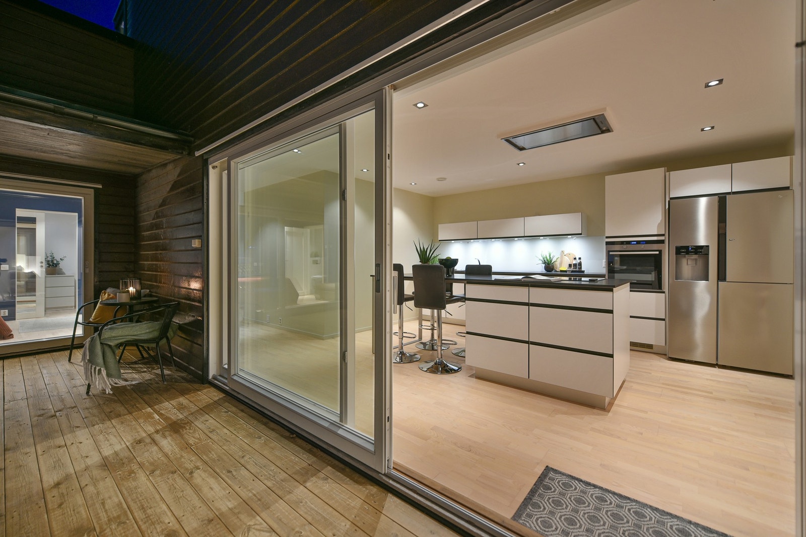 I 1. etasje er det store skyvedører i glass inn til kjøkken, stue og hovedsoverom. Galleribilde