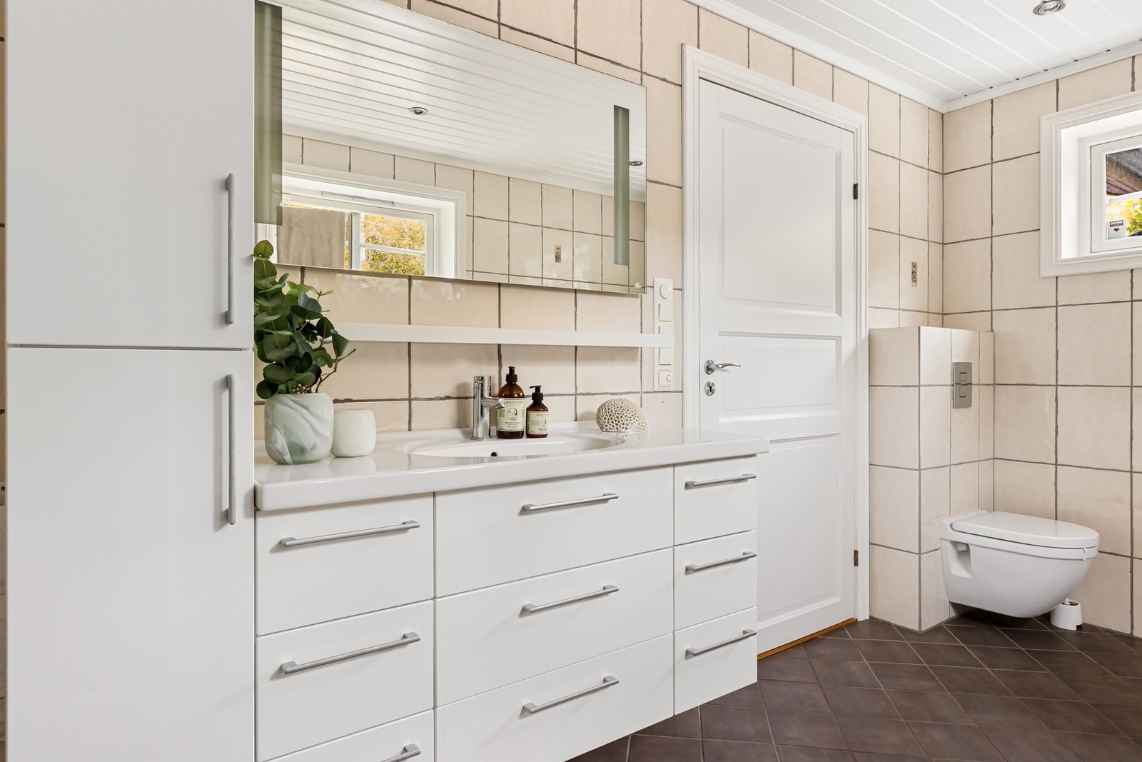 Godt med oppbevaring i stilrent servantskap med skuffer og skap, kombinert med speil med integrert belysning Galleribilde