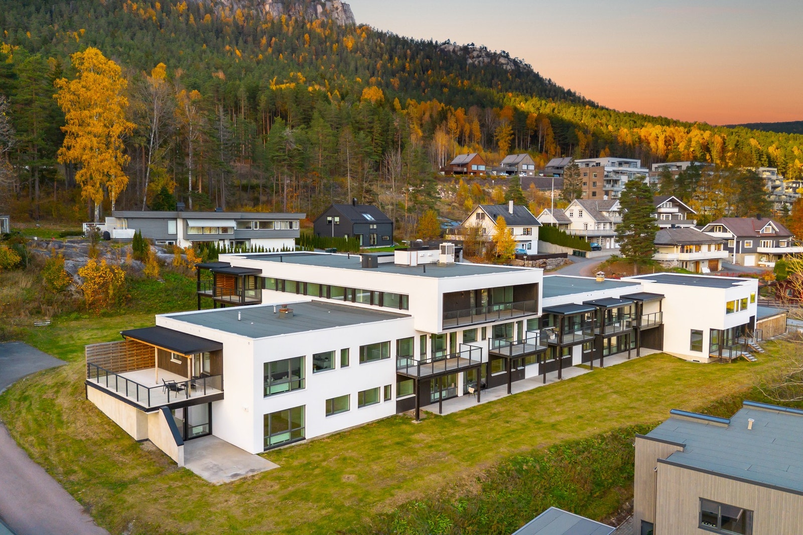 Moderne boligkompleks med store vinduer og balkonger, omgitt av natur. Galleribilde