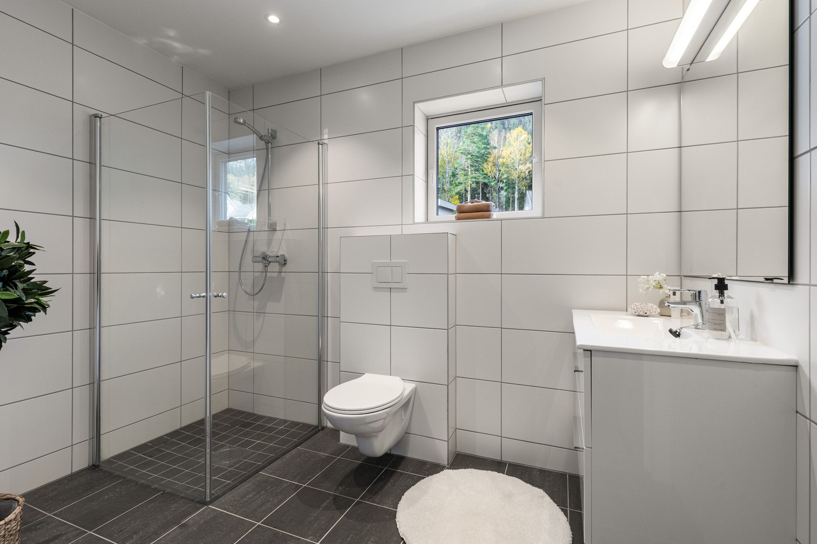 Moderne, helflislagt bad med tidløst design og varmekabler i gulvet. Galleribilde