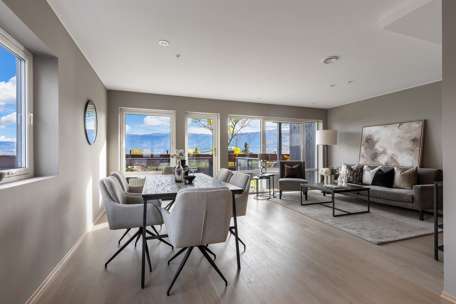 Lys og romslig stue- og spiseområde med store vinduer som gir mye naturlig lysinnslipp og utsikt. Galleribilde