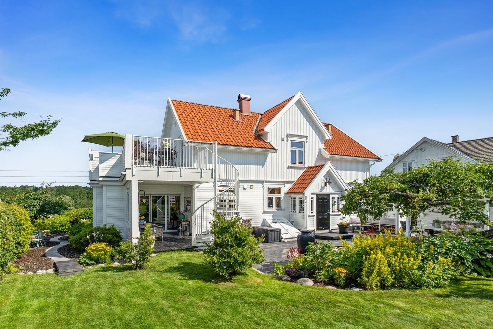 Det moderne tilbygget er fra 2023. Arkitektens løsninger får inne- og uterom til å flyte elegant sammen. Den spenstige vindeltrappen leder deg fra hagen og opp til en stor solrik terrasse med vakkert utsyn. Galleribilde