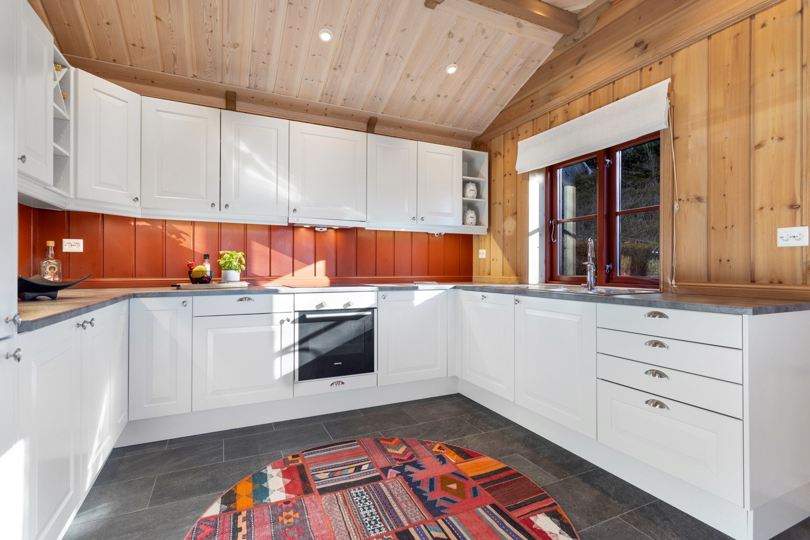 Innredningen har integrerte hvitevarer som; Kjøleskap med frysedel, stekeovn, platetopp, mikrobølgeovn og oppvaskmaskin Galleribilde