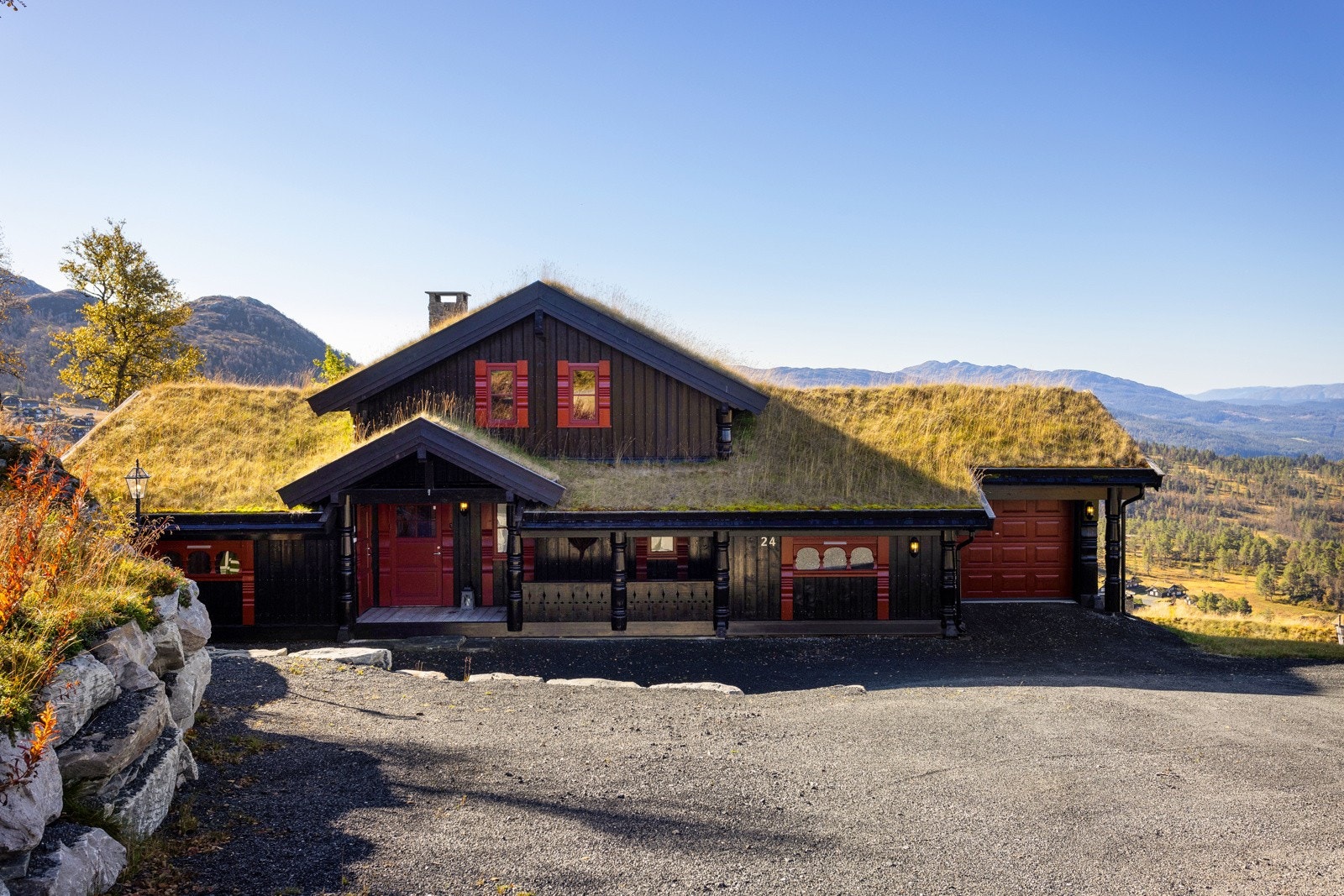 Stor parkeringsplass tilknyttet hytta, opparbeidet med flotte natursteinsmurer. Garasje med elbil-lader og elektrisk port tilknyttet hytta Galleribilde