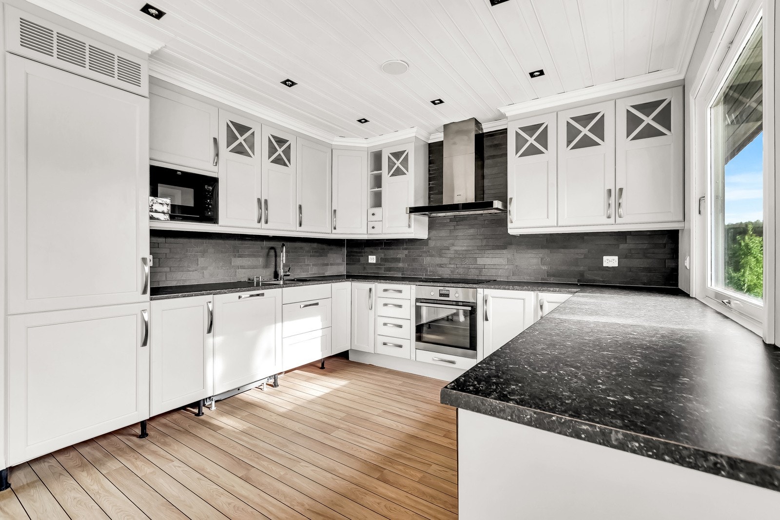 Pent kjøkken fra 2011 med innredning med profilerte fronter og benkeplate med vaskekum. Galleribilde