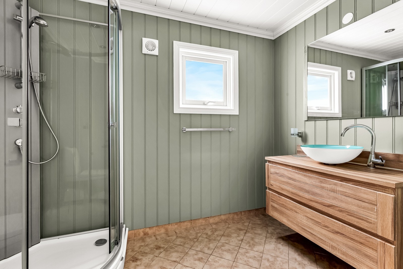 Bad fra 2006 med varme i gulvet, og vegghengt servantinnredning med skuffer og ovenpåliggende servant. Dusjkabinett og gulvstående toalett. Galleribilde