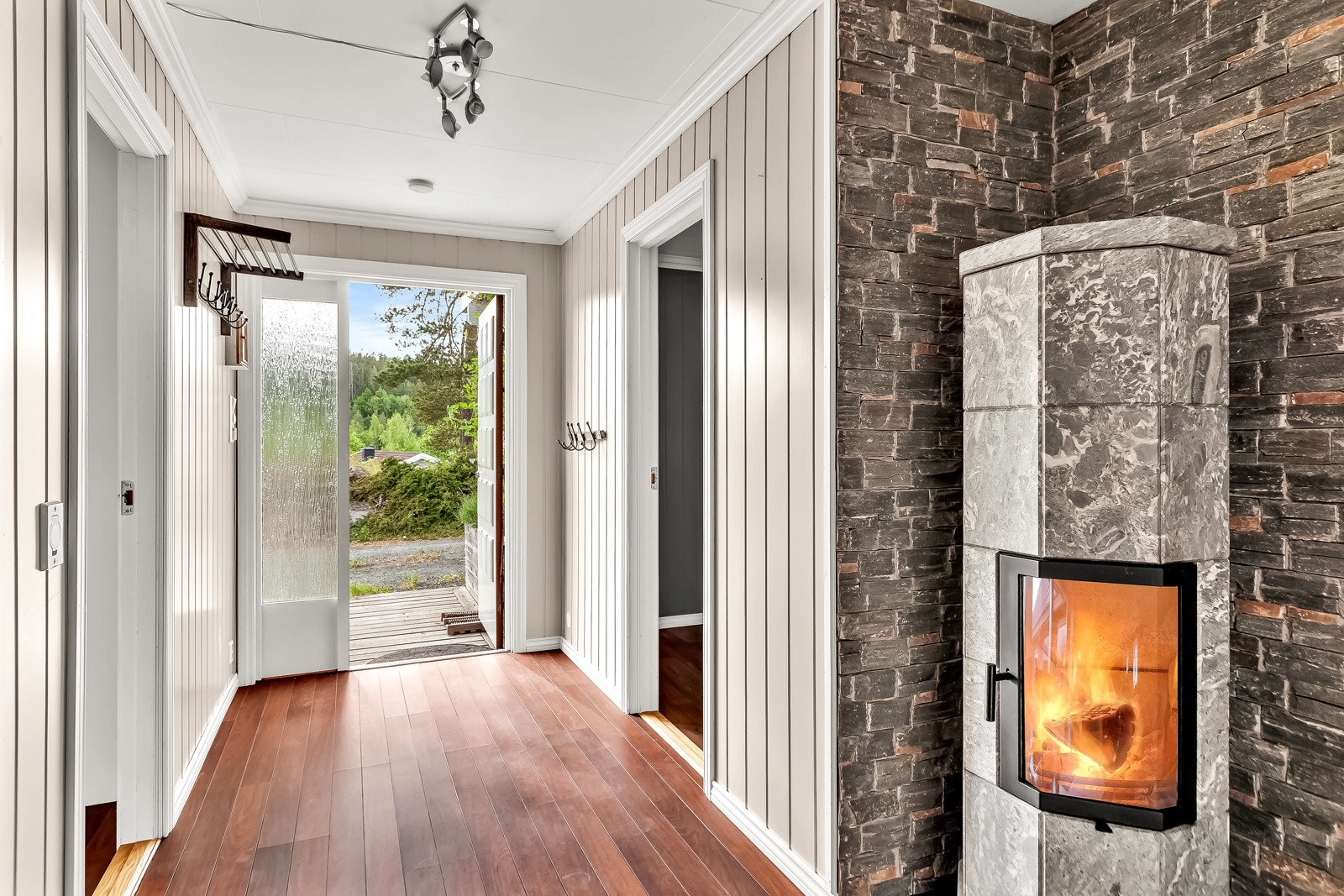 Romslig entré/hall med plass til oppheng for jakker. Peisovn med glassdør. Galleribilde