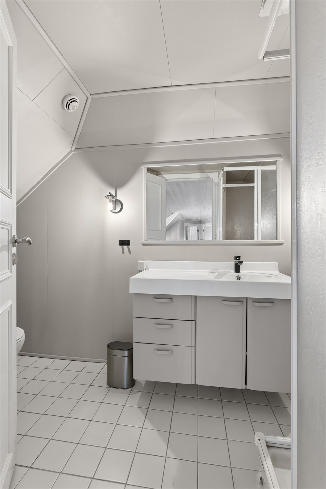 Baderommet i loftsetasjen er utstyrt med gulvstående klosett, et dusjkabinett og servant med tilhørende underskap. Galleribilde