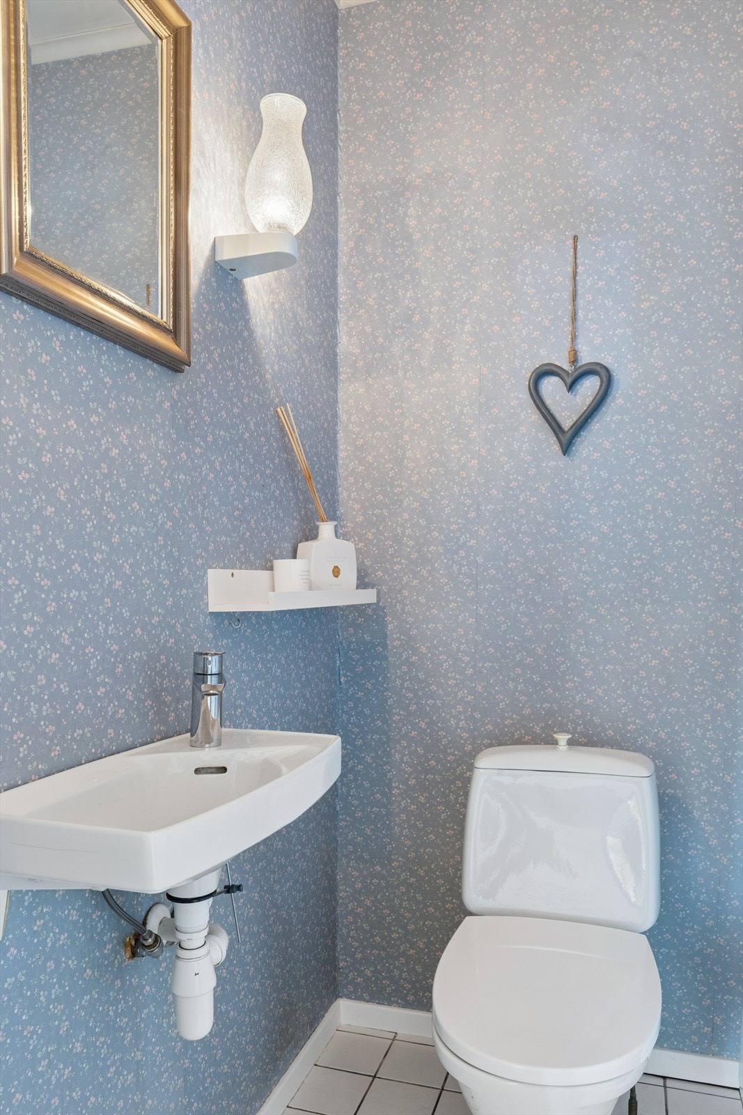 Separat toalettrom utstyrt med gulvstående klosett og en vegghengt servant. Galleribilde