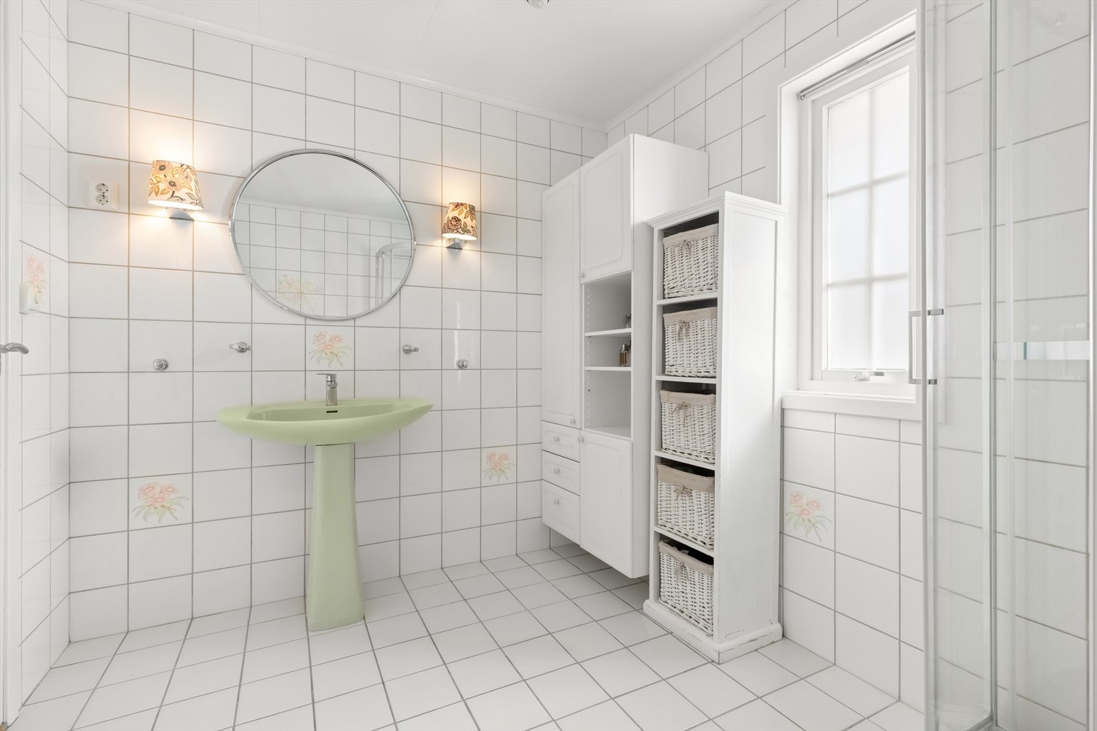 Rommet er utstyrt med et praktisk veggskap med hyller, skuffer og skap, samt belysning på vegg over servanten. Galleribilde