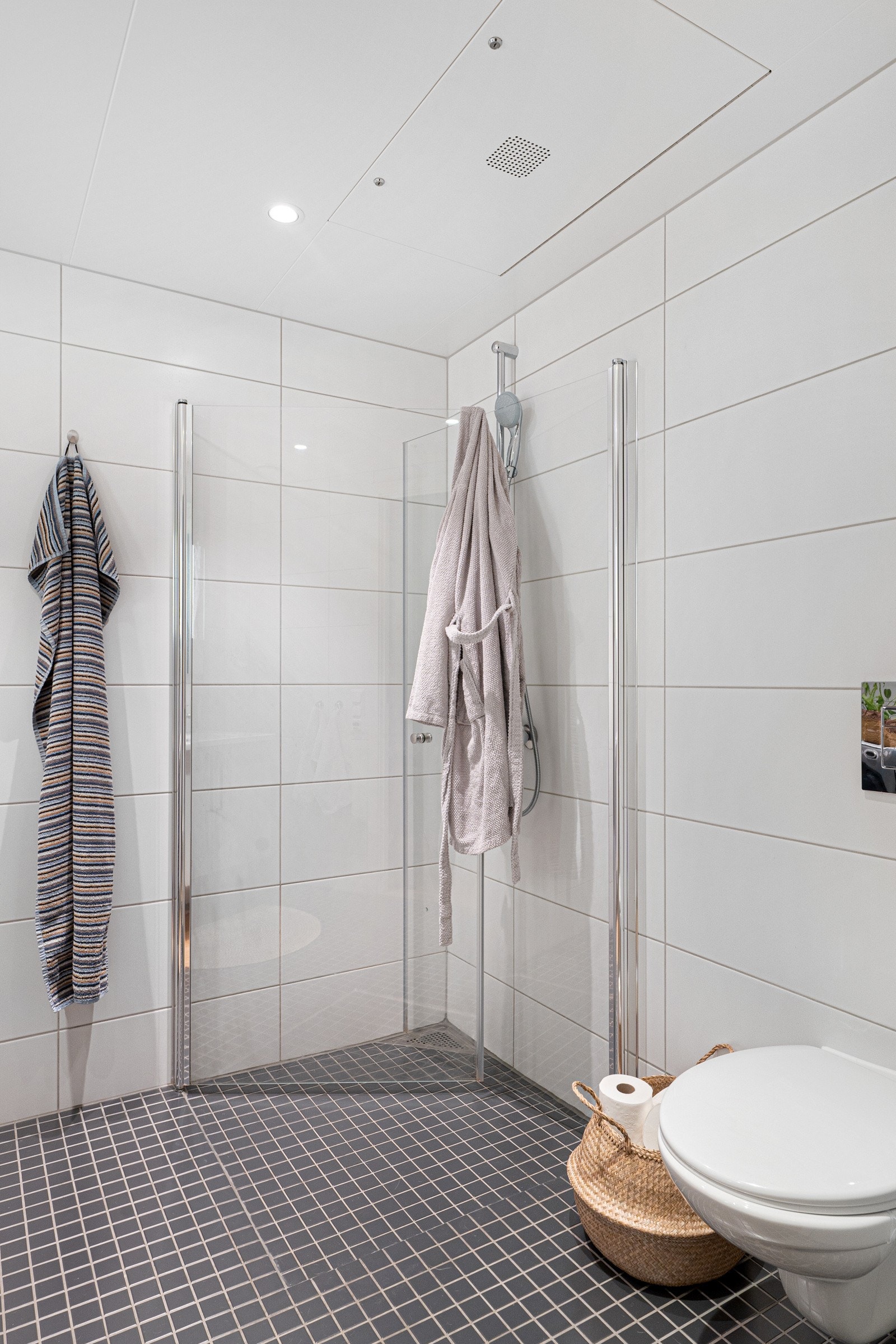 Badet oppleves svært praktisk og funksjonelt, og er videre utstyrt med heldekkende servant, veggmontert toalett, opplegg for vaskemaskin og dusjhjørne med innfellbare dører, for optimal plassutnyttelse. Det er selvfølgelig behagelig varme i gulv. Galleribilde