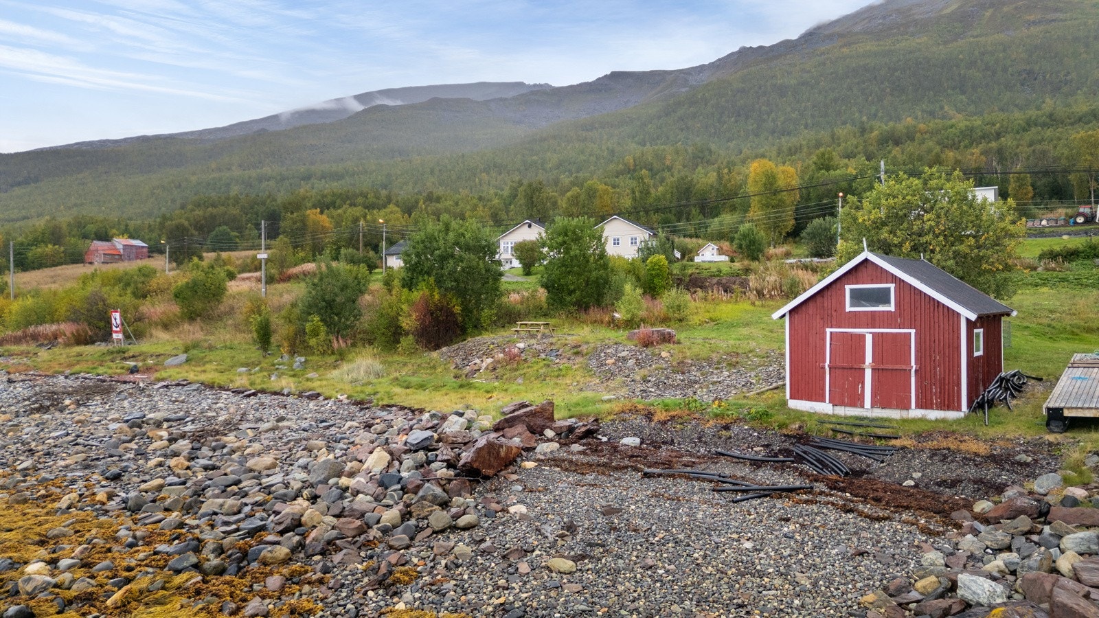 Strandlinje med ett naust, perfekt for deg som drømmer om livet ved fjorden.