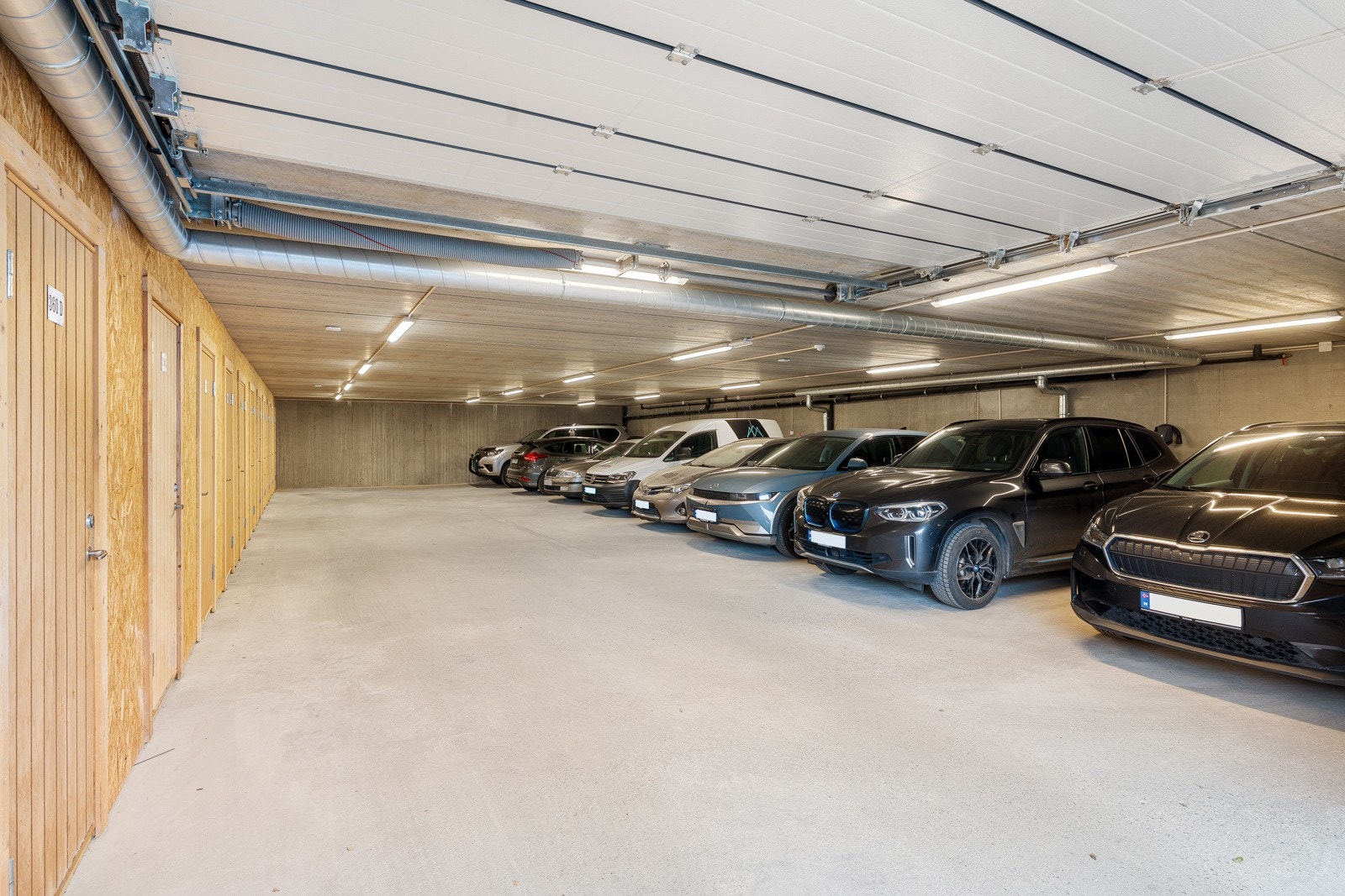 Parkering i garasje utenfor nabobygg med opplegg for el-bil lader, her finner du også en egen sportsbod for ekstra lagringsplass.
