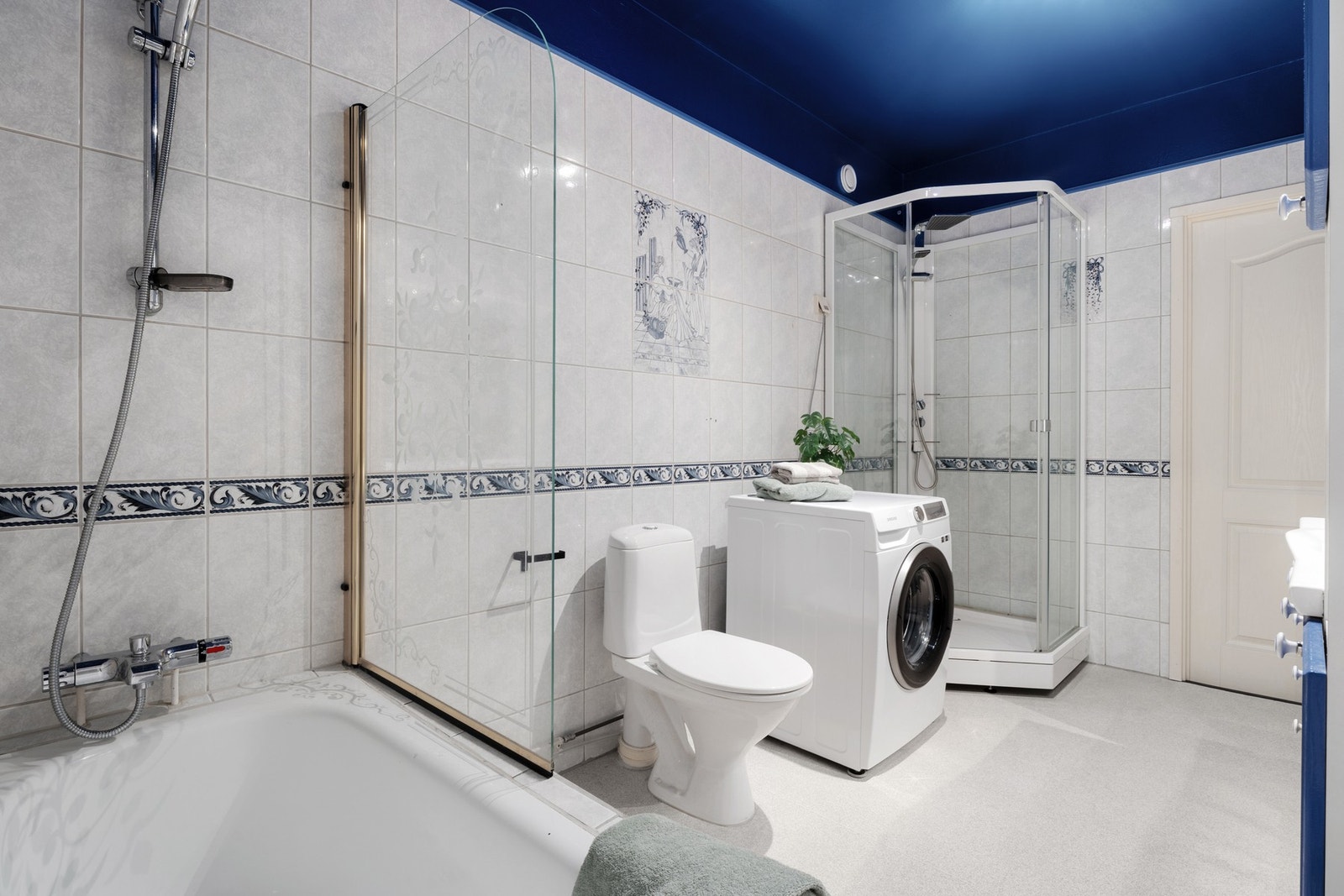 Badet er utstyrt med dusjkabinett med skyvedør, innbegygd badekar med dusjvegg, gulvmontert klosett, samt servant med tilhørende servantinnredning. Galleribilde