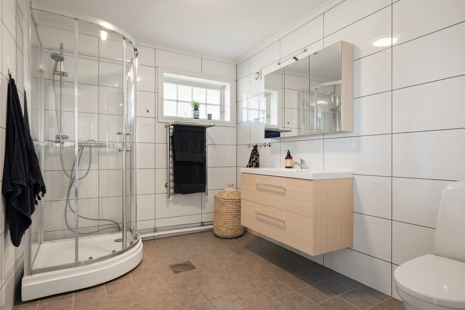 Badet i 2. etasje er også helfliset og utstyrt med innredning med nedfelt servant, toalett og dusjkabinett. Rommet har varmekabler Galleribilde