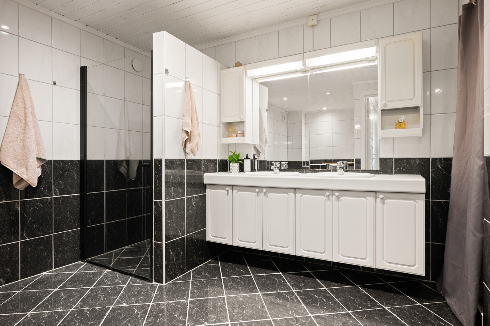 Badet i første etasje har fliser på vegger og gulv Galleribilde