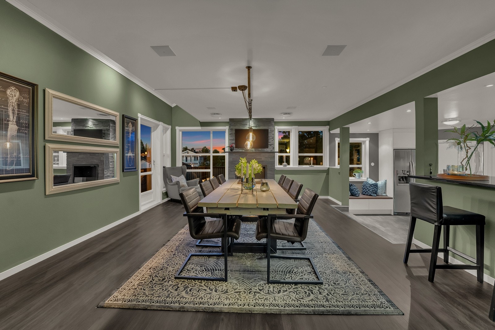 Spisestuen prydes av en murt bio-peis kledd i grå naturstein, med oppheng for flatskjerm i overkant. Galleribilde